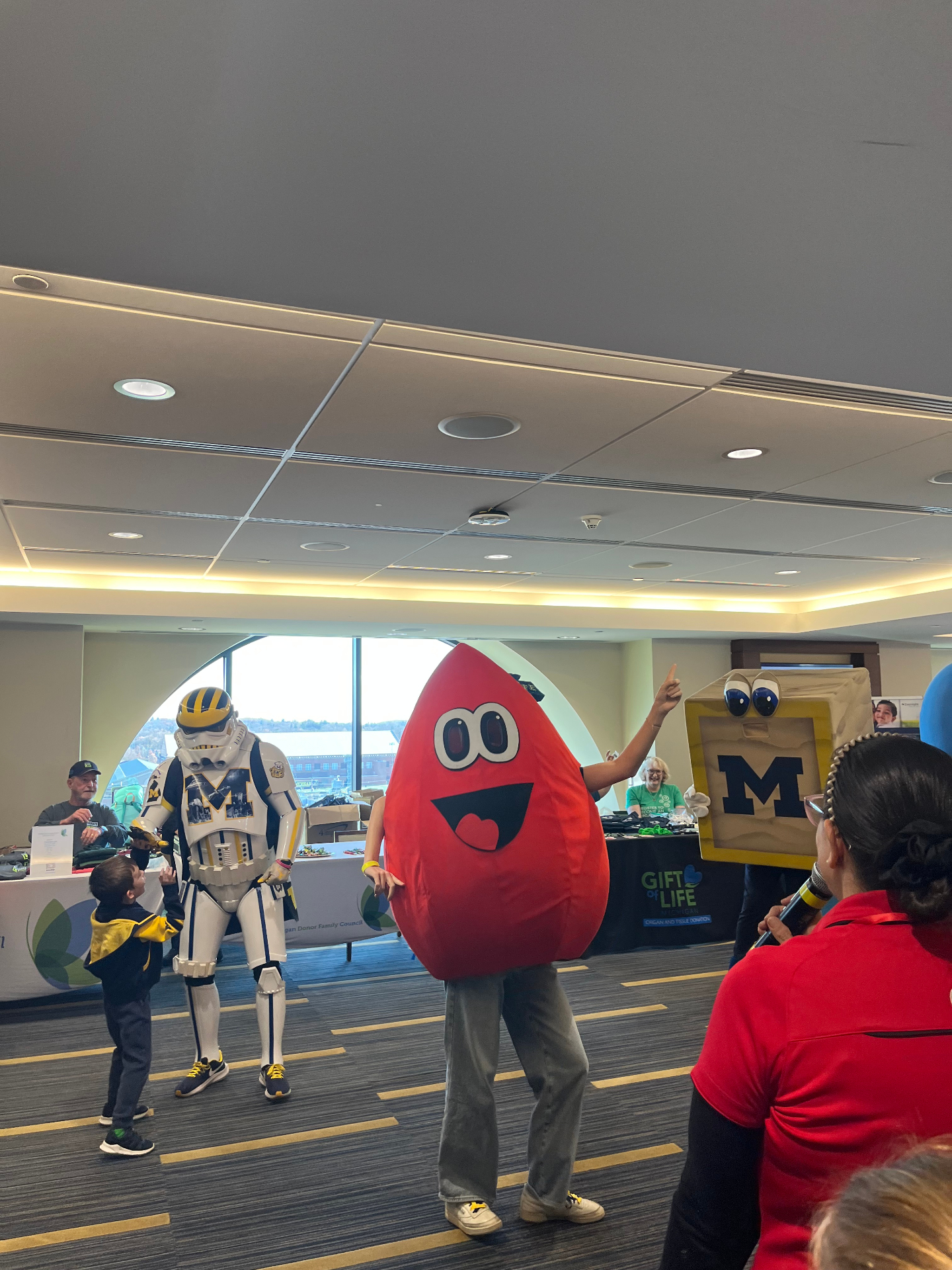 Blood drop mascot with Michigan stormtrooper and block M mascot at an indoor drive