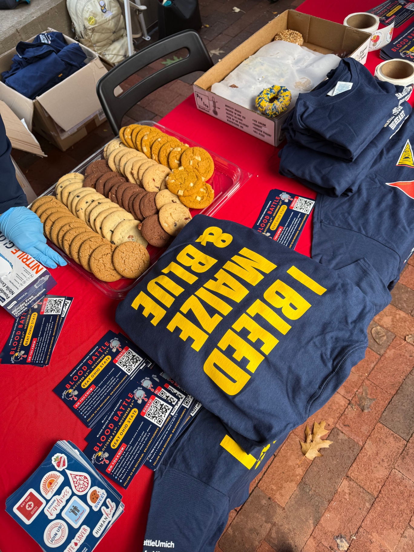 Blood Battle shirts, flyers, stickers, and cookies at a tabling event