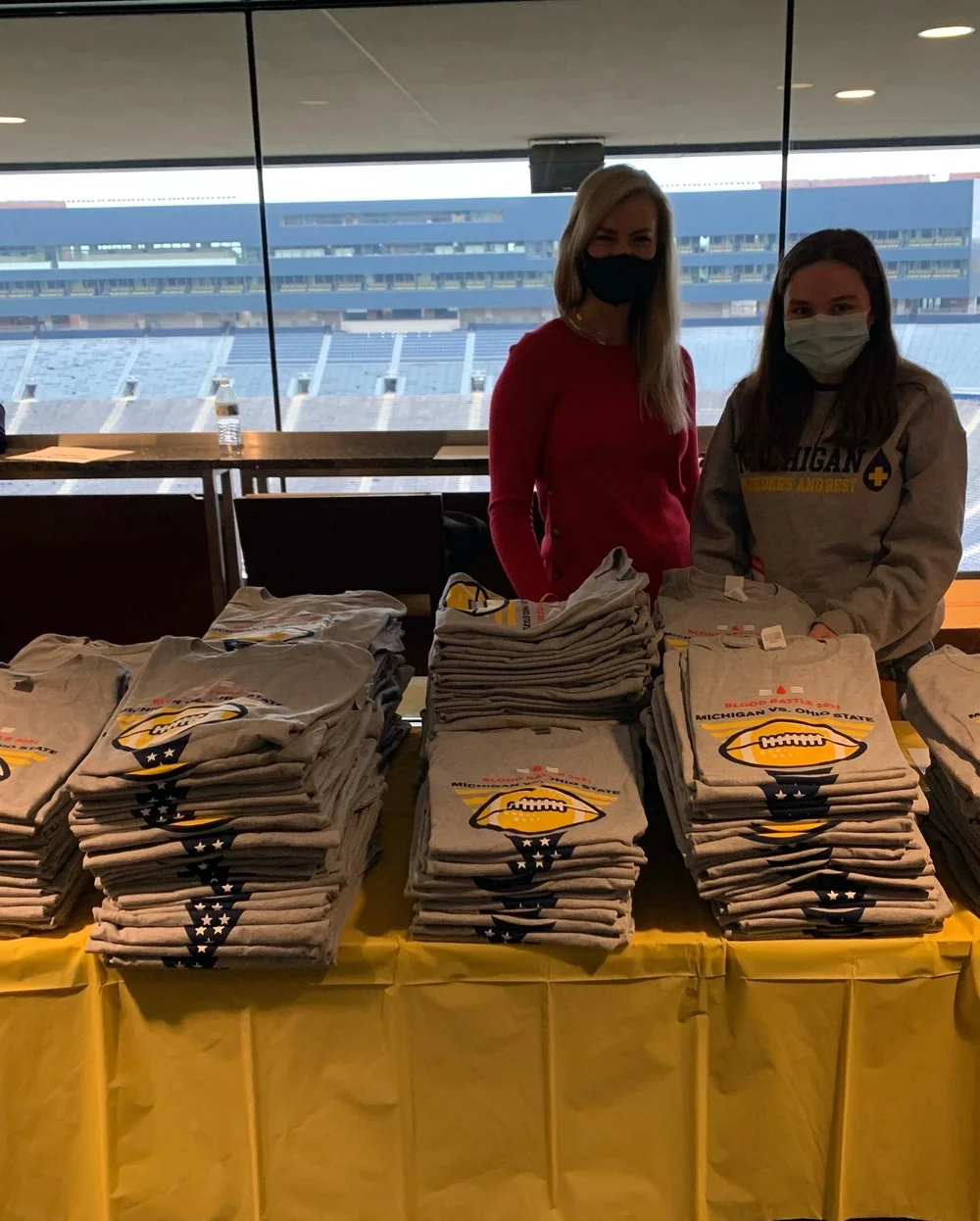 Volunteers organizing Blood Battle shirts inside Michigan Stadium